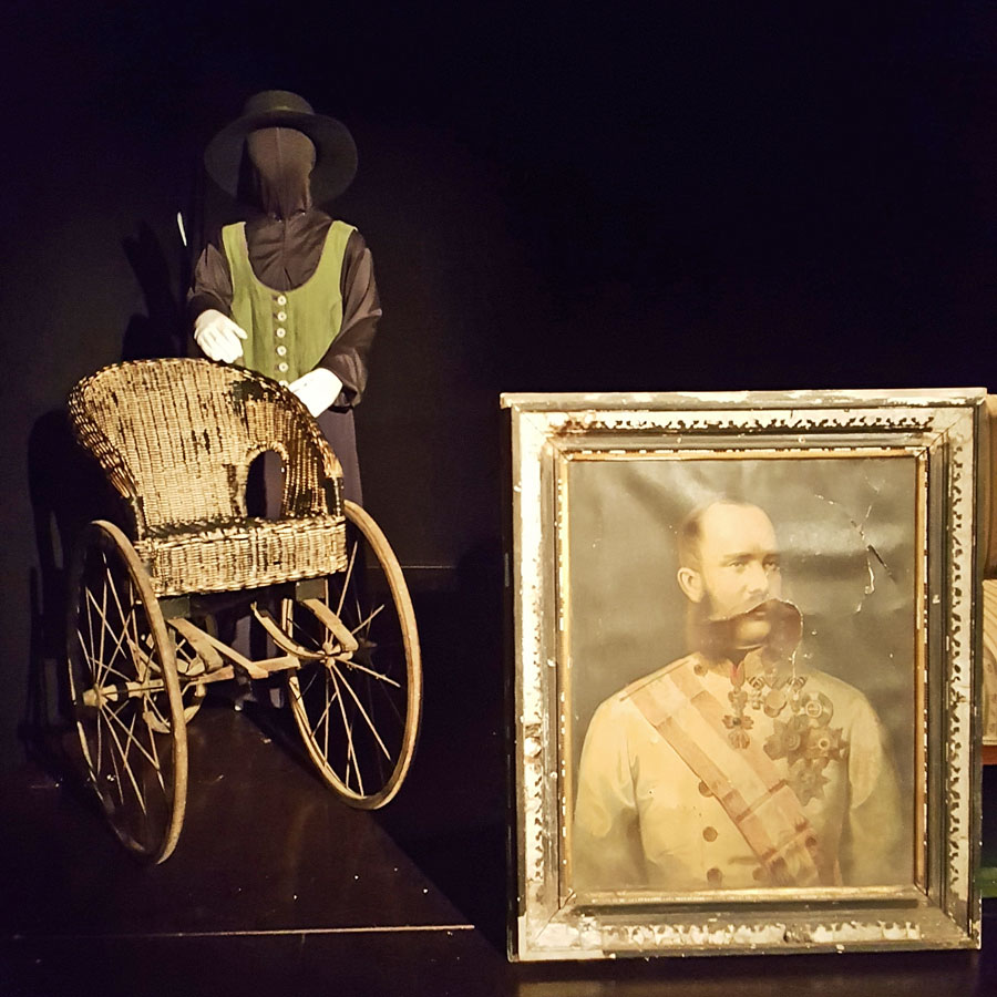 Links: Das Kaiserbild und der Rollstuhl